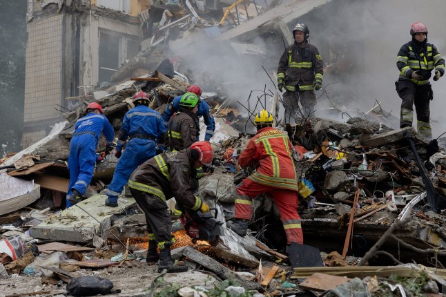 TOPSHOT - Rescuers clear debris as they work at the site of a destroyed residential building following a Russian air attack in Kyiv on July 31, 2025, amid the Russian invasion of Ukraine. (Photo by Tetiana DZHAFAROVA / AFP) (Photo by TETIANA DZHAFAROVA/AFP via Getty Images)