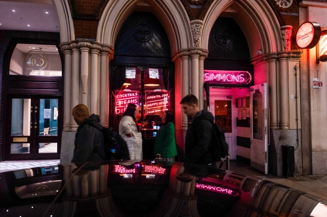 Commuters pass customers outside a Simmons Bar in the City of London, UK, Tuesday, Nov. 7, 2023. City center pubs, still in recovery mode in the post-Covid era, face sliding revenue and rising costs. Photographer: Jose Sarmento Matos/Bloomberg via Getty Images