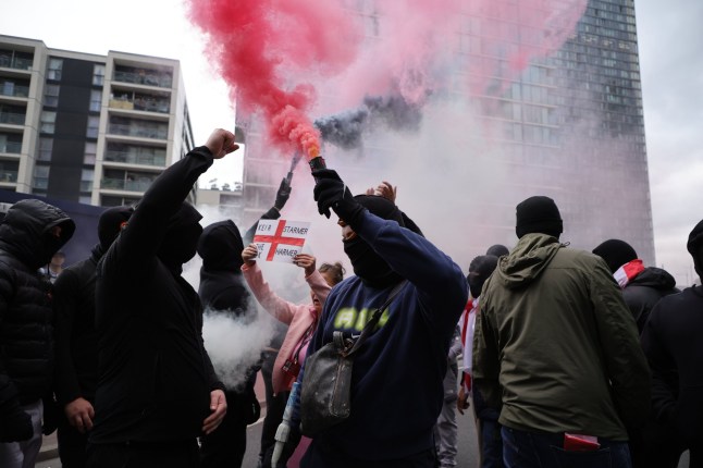 ??George Cracknell Wright 03/08/2025 London, United Kingdom Anti Migrant Hotel protest Canary Wharf Masked anti migrant protestors arrive with flares and clash with police as other anti migrant protesters block the road as they gather outside the Britannia International Hotel in east London. The hotel recently received two coach loads of suspected asylum seekers after being cleared by the Home Office. Photo Credit: George Cracknell Wright