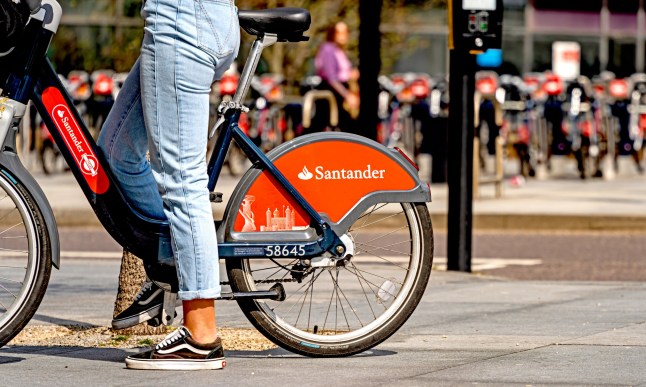 A person on a Santander bike in a London street.
