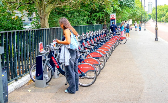 A person hiring a Santander bike in London on the street.