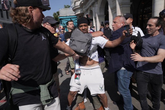 A pro-Palestinian supporter (centre, in white) is removed after interrupting the National March For The Hostages in central London, with family members of hostages being held by Hamas terrorists, Jewish community leaders and antisemitism campaigners taking part. Picture date: Sunday August 10, 2025. PA Photo. Photo credit should read: Stefan Rousseau/PA Wire