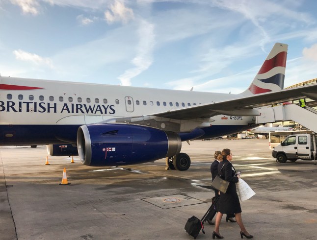 British Airways air stewards walking past a plane at Heathrow Airport.