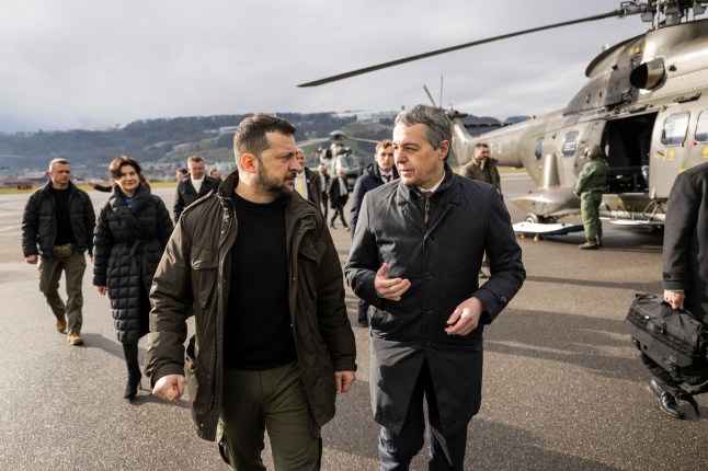 Ukrainian president Volodymyr Zelensky (C) is welcomed by Switzerland's Foreign Minister Federal Councillor Ignazio Cassis