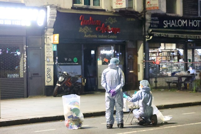 Investigators in white suits outside a restaurant