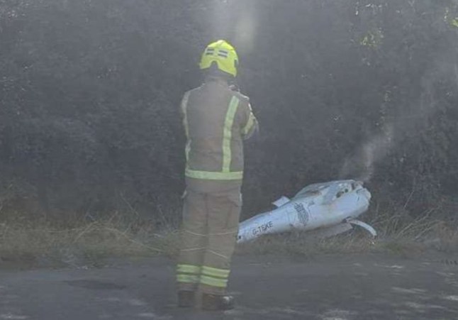 Emergency services are investigating after??reports of a Home Office surveillance drone on fire beside the M20 near Folkestone this afternoon. The incident is believed to have occurred on the coastbound carriageway between Junction 13 (Folkestone) and Junction 12 (Cheriton). Home Office Surveillance Drone Fire Near M20 near Folkestone Drone Registration Reported Eyewitnesses reported seeing smoke and wreckage at the roadside, with some suggesting the registration number ???G-TEKE??? could be seen on the drone or equipment. It is not yet clear whether the device crashed during flight or was being transported by road when the fire started. Home Office Surveillance Drone Fire Near M20 near Folkestone Firefighters attended the westbound carriageway between Junction 13 (Folkestone) and Junction 12 (Cheriton) shortly after 2pm. Drone Found on Hard Shoulder Photos taken at the scene show an upturned aircraft with Home Office branding, with smoke rising from the fuselage as firefighters worked nearby. Dashcam footage also shows smoke drifting across the motorway, with one fire engine and crew in attendance. Initially, National Highways described the incident as a vehicle fire. However, closer images show the drone bearing the registration G-TEKE. Home Office Surveillance Drone Fire Near M20 near Folkestone Tekever AR5 Drone Flight records suggest the aircraft is a Tekever AR5 Evolution MK2, a long-endurance drone designed for maritime surveillance missions. According to manufacturer specifications, the AR5 can fly for more than 20 hours, carrying maritime radars and day/night cameras. In 2023, the Home Office signed a three-year contract with Tekever to deploy AR5 drones over the English Channel as part of its Small Boats Operational Command, which tracks migrant crossings. Cause Unknown It is not yet clear whether the drone crashed in flight or fell from a transport vehicle. By 3pm, traffic had cleared and both motorway lanes had reopened. The