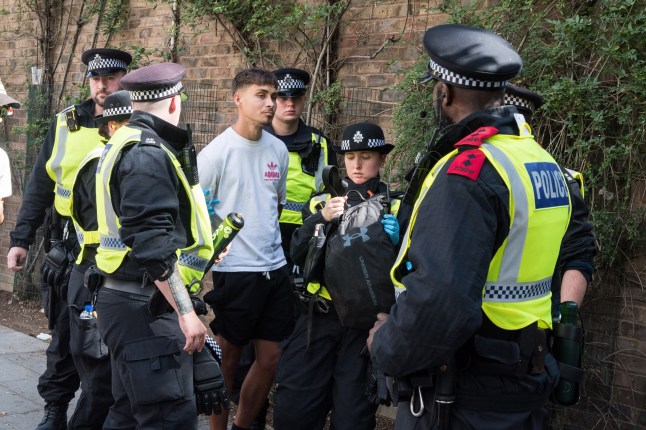 LONDON, UNITED KINGDOM - AUGUST 25: Police officers detain a reveller on the second day of Notting Hill Carnival in London, United Kingdom on August 25, 2025. Two million revellers are expected to take part in Notting Hill Carnival, Europe's largest street party and a celebration of African-Caribbean traditions and the capital's cultural diversity. (Photo by Wiktor Szymanowicz/Anadolu via Getty Images)