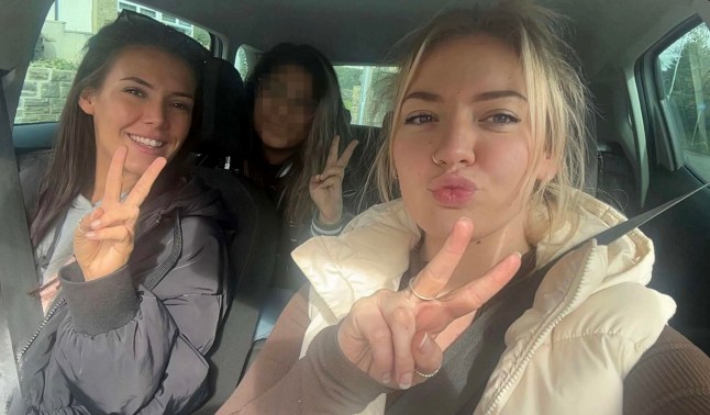 Ebony Cordingley (left) and Lauren Homes (right) sitting in a car with two fingers in a peace sign and smiling