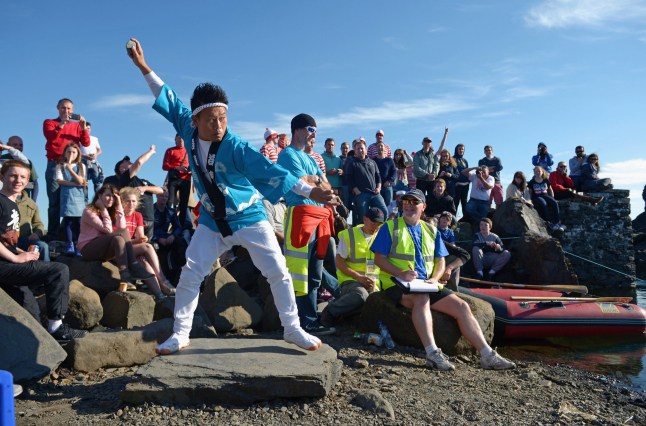 TV star Daisuke Miyagawa pictured taking part in the World Stone Skimming Championships, held on Easdale Island on September 29, 2013 in Easdale, Seil, Scotland. The championships are held on the last Sunday in September each year on Easdale which is the smallest inhabited island of the Inner Hebrides. EASDALE, SEIL, SCOTLAND - SEPTEMBER 29: (Photo by Jeff J Mitchell/Getty Images)