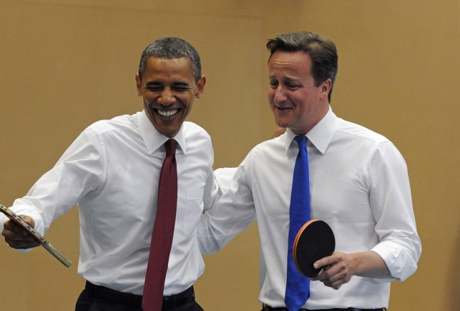 Barack Obama and David Cameron smiling holding table tennis bats
