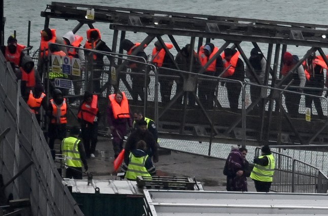 (FILES) Migrants picked up at sea attempting to cross the English Channel from France, disembark from Border Force vessel 'Typhoon' after it arrived at the Marina in Dover, southeast England, on February 9, 2025. More than 50,000 people have made the perilous Channel crossing to the UK in small boats since Keir Starmer became prime minister last July, official figures showed on August 12, 2025. (Photo by Ben STANSALL / AFP) (Photo by BEN STANSALL/AFP via Getty Images)