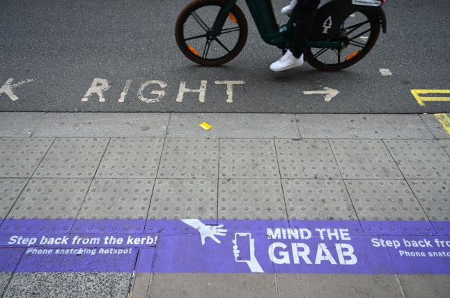 LONDON, UK - AUGUST 18: Warning signs placed on a sidewalk at Oxford Street by the British Transport Police informing passengers to be cautious against pickpockets and electronic device thieves in London, United Kingdom on August 18, 2025. (Photo by Rasid Necati Aslim/Anadolu via Getty Images)