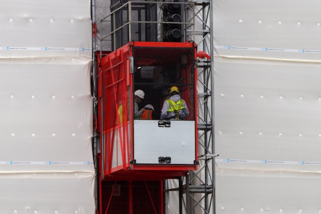 ? Licensed to London News Pictures. 20/08/2025. London, UK. Workmen are seen in a lift travelling to the upper floors of Grenfell Tower in west London as a crane is installed and preparatory works begin ahead of its deconstruction, following the UK government?s approval on 7 February 2025. In July 2025, the Department for Levelling Up, Housing and Communities (DLUHC) confirmed the deconstruction will proceed. The tower will be carefully dismantled behind its white wrapping, one floor at a time ? around a month per floor ? with scaffolding changes allowing a second ?green heart? banner to be placed and moved down in stages. The process aims to minimise disruption and respect the site where 72 people died in the 2017 fire. Photo credit: Dinendra Haria/LNP