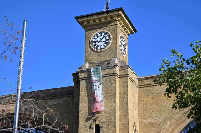 A man holding a dog on King's Cross clocktower.