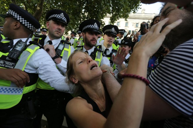 LONDON, ENGLAND - SEPTEMBER 6: A protester reacts to a man after he is thrown to the floor by police officers during the protest in Parliament Square on September 6, 2025 in London, England. The UK Government will be able to challenge the decision to allow activist group Palestine Action's appeal against their proscription as a terrorist organisation. (Photo by Martin Pope/Getty Images)