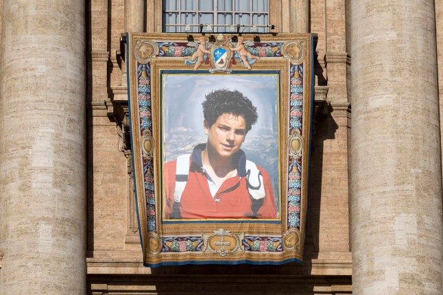 epa12358946 The portrait of Carlo Acutis in St. Peter's Square for the canonization of Carlo Acutis and Piergiorgio Frassati, at the Vatican, 07 September 2025. Carlo Acutis, an Italian teenager who died in 2006, will be canonized by Pope Leo XIV in a ceremony at the Vatican, becoming the first millennial saint. EPA/MASSIMO PERCOSSI